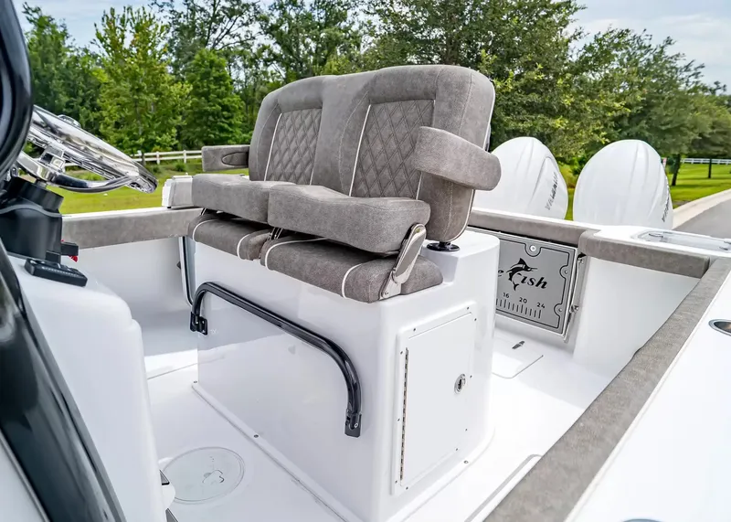 Slide: The Image of The image shows the helm of a Sea Hunt Gamefish 25 boat with cushioned seating. - 19
