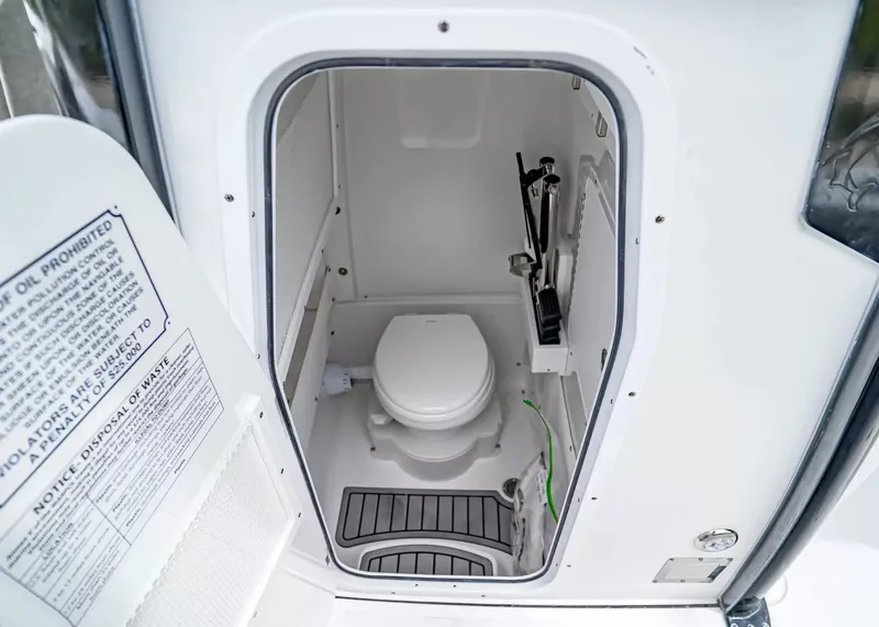 Slide: The Image of The image shows a compact boat toilet with a white seat and gray flooring. - 20