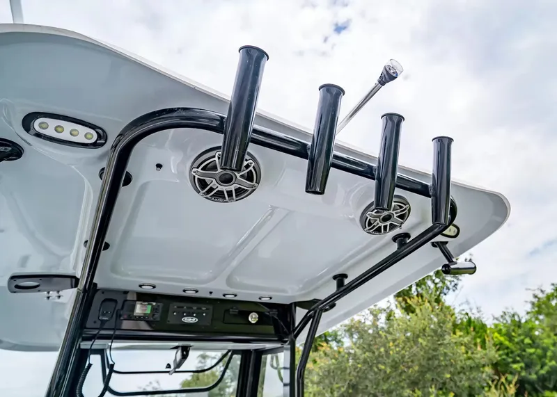 Slide: The Image of The image shows the T-top structure of a Sea Hunt Gamefish 25 with rod holders and speakers. - 14