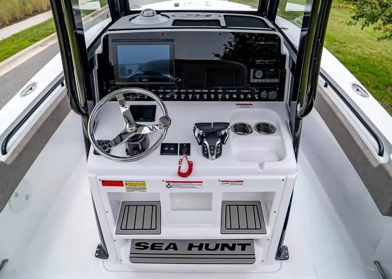 Slide: The Image of The image shows the helm of a Sea Hunt Gamefish 25 boat with modern instruments and controls. - 16