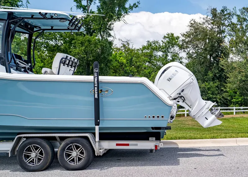 Slide: The Image of A Sea Hunt Gamefish 27 Coffin Box boat on a trailer, featuring a Yamaha outboard motor. - 3