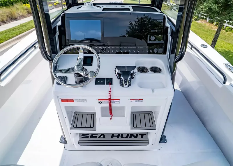 Slide: The Image of The cockpit of the 2027 Sea Hunt Gamefish 27 Coffin Box features a modern helm with steering wheel and electronics. - 18