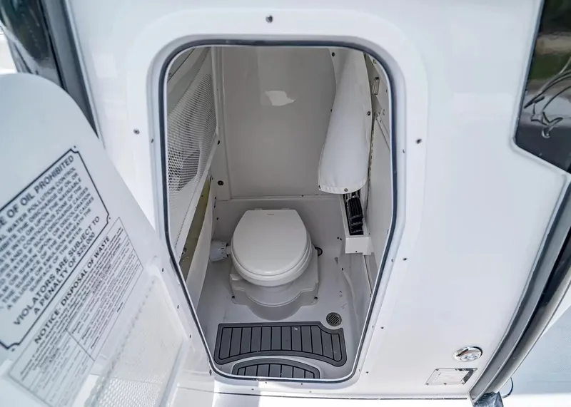 Slide: The Image of The image shows a compact boat toilet with gray flooring and white walls. - 21