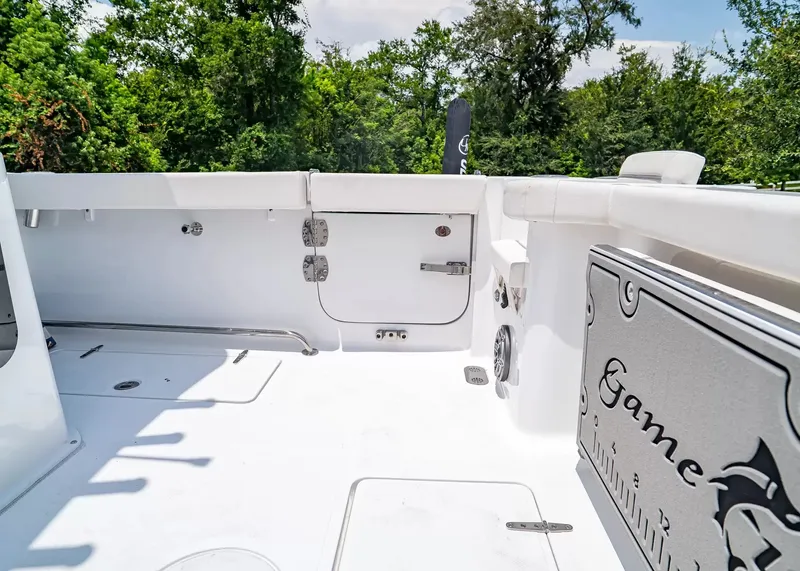 Slide: The Image of The image shows the deck of a 2027 Sea Hunt Gamefish 27 Coffin Box boat with white upholstery. - 8