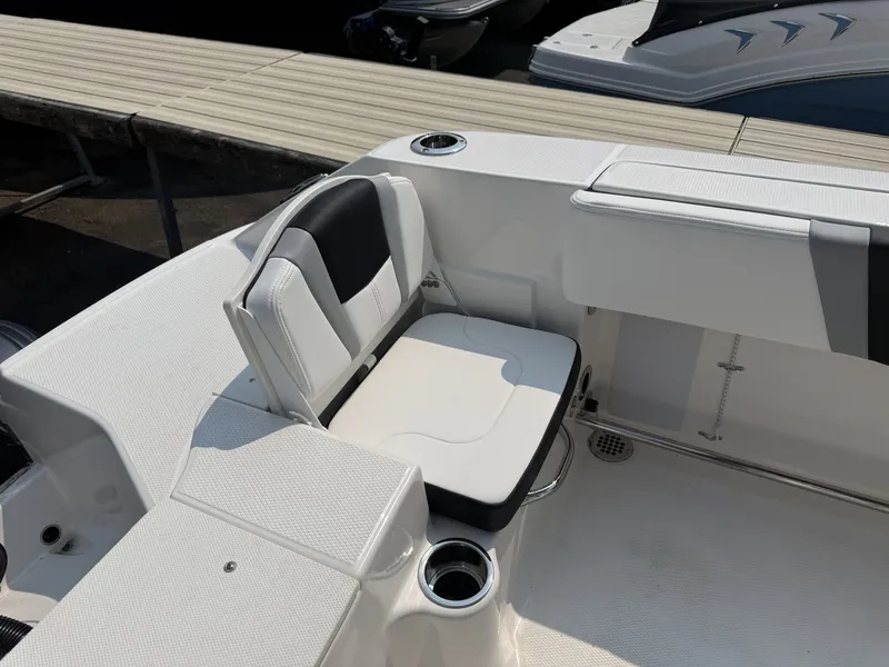 Slide: The Image of The image shows the seating area of a 2027 Robalo R200 Center Console boat with white upholstery. - 8