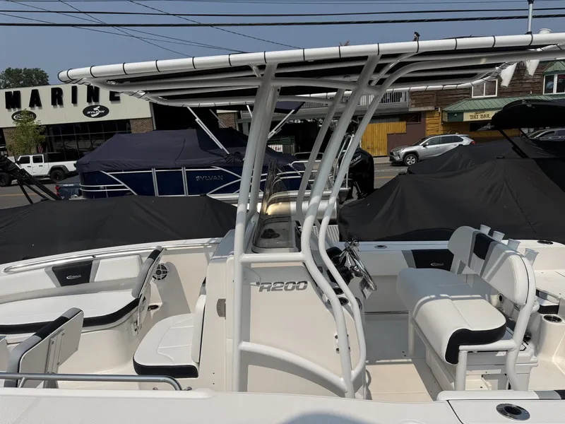 Slide: The Image of The image shows a 2027 Robalo R200 Center Console boat with a T-top and seating. - 3