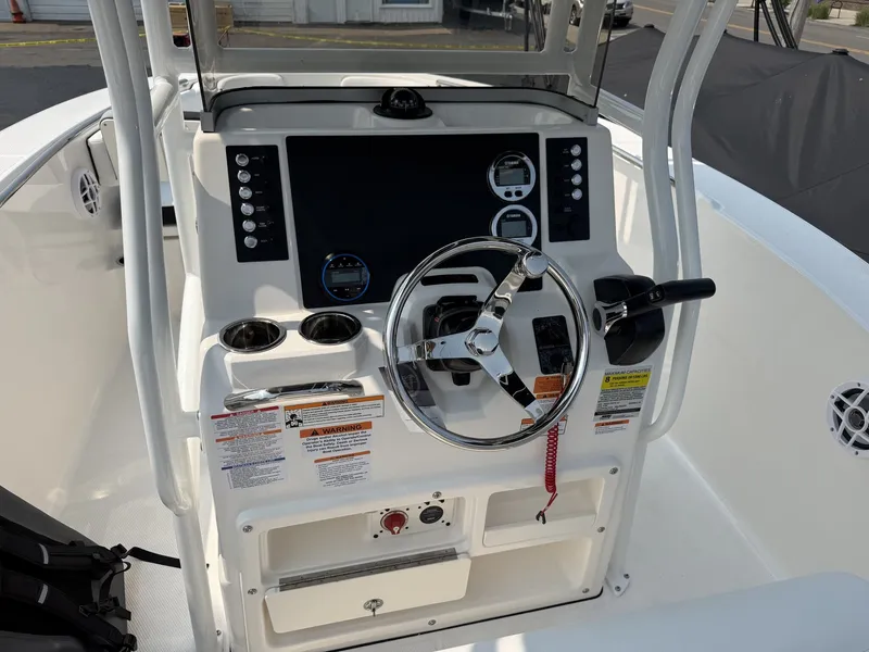 Slide: The Image of The image shows the helm of a Robalo R200 Center Console boat. It features a modern design with a large screen, steering wheel, and various controls. - 7
