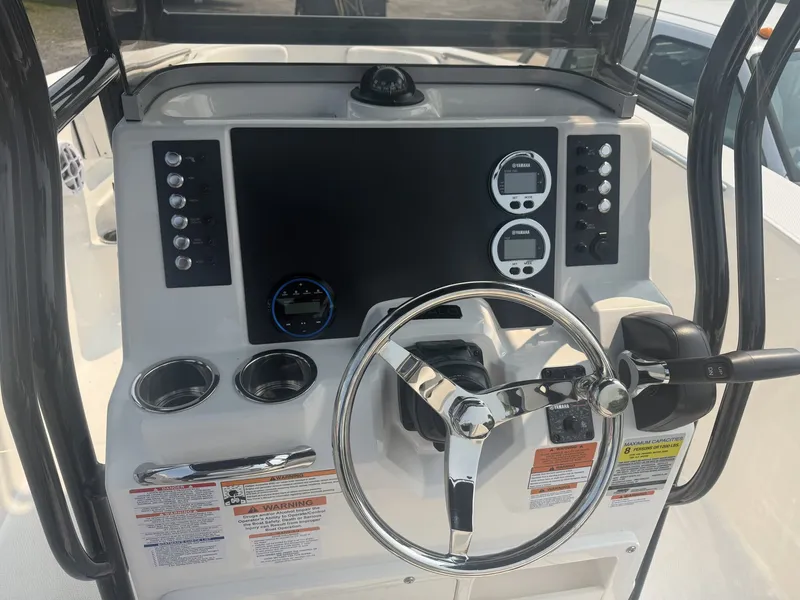 Slide: The Image of The image shows the helm of a Robalo R200 Center Console boat. It features a modern dashboard with multiple gauges and a shiny steering wheel. - 5