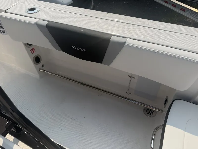 Slide: The Image of The image shows the interior of a 2027 Robalo R200 Center Console boat. There's a cushioned bench with a black insert and a stainless steel grab rail below. - 12