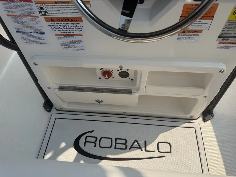 Slide: The Image of The image shows the helm of a Robalo R200 Center Console boat with warning labels and a Robalo logo. - 6