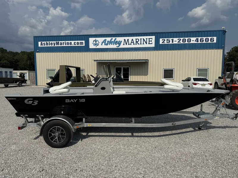 The Image of A G3 Bay 18 BAY-F90 SHO boat on a trailer in front of a building labeled "Ashley Marine." - 1