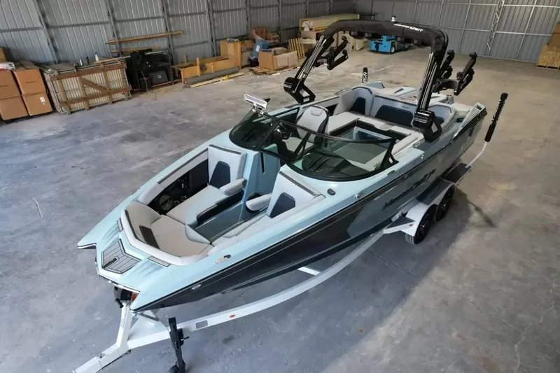 Slide: The Image of The image shows a 2024 MasterCraft XStarS boat in a warehouse. It features a modern design with gray and blue accents. - 16