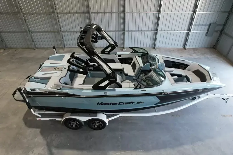 Slide: The Image of A 2024 MasterCraft XStarS boat in a warehouse. It features a modern design and a trailer. - 3