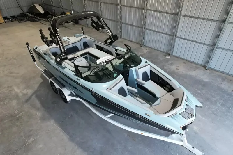 Slide: The Image of A 2024 MasterCraft XStarS boat is in a warehouse. It features a modern design and a trailer. - 20