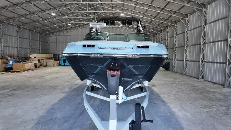 Slide: The Image of A 2024 MasterCraft XStarS sits on a trailer in a large warehouse. - 19