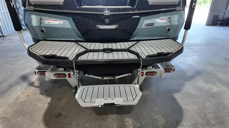 Slide: The Image of The image shows the rear of a 2024 MasterCraft XStarS with a modern swim platform. - 10