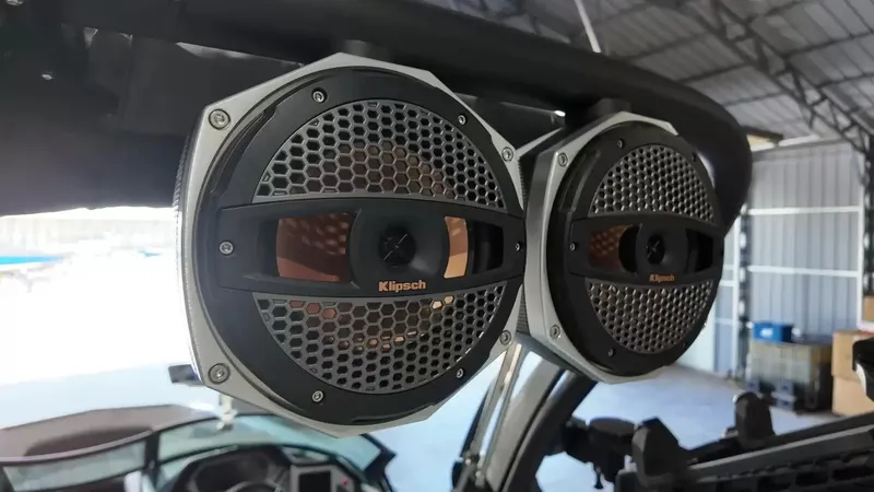 Slide: The Image of Two large speakers are mounted on a boat situated in a covered area. - 34