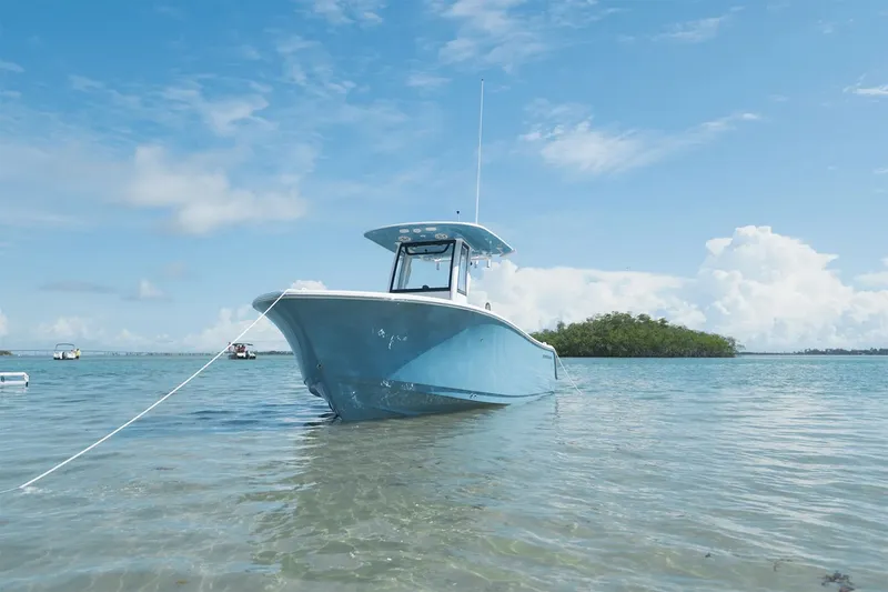 Slide: The Image of A 2025 Sportsman Open 232 Center Console boat anchored in shallow, clear water. - 21