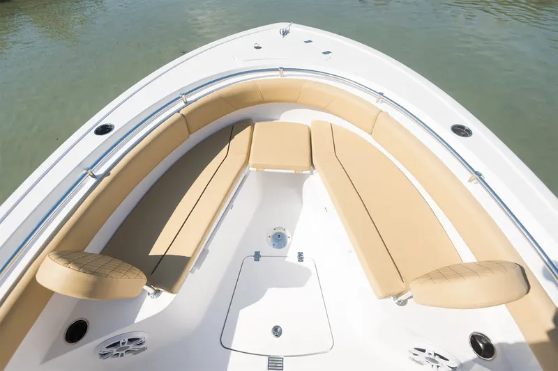 Slide: The Image of The image shows the bow of a Sportsman Open 232 Center Console boat with beige cushions. - 4