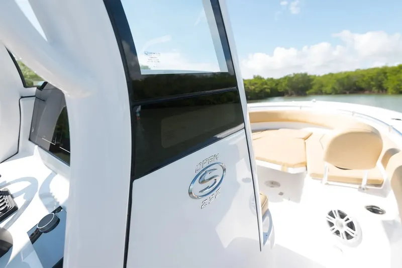 Slide: The Image of The image shows the cockpit of a 2025 Sportsman Open 232 Center Console boat. It features a modern design with a beige seating area and a clear view of the water. - 8