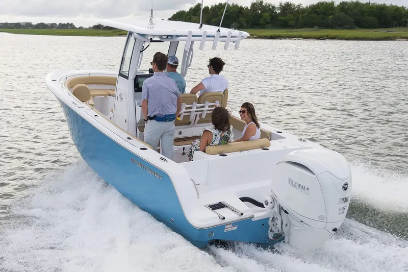 Slide: The Image of A 2025 Sportsman Open 232 Center Console boat on a river with five people aboard. - 19