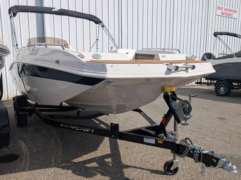 Slide: The Image of A 2025 Starcraft SVX 171 OB boat on a trailer in front of a building. - 2