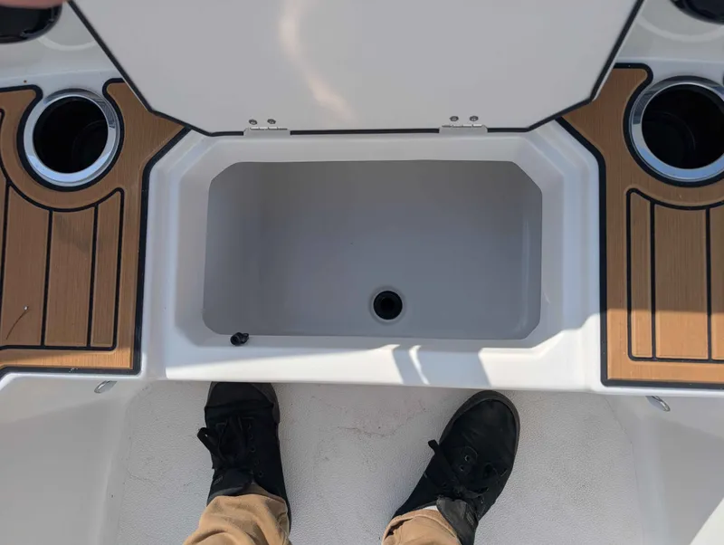 Slide: The Image of An open storage compartment on a boat with wood paneling and cup holders. - 7