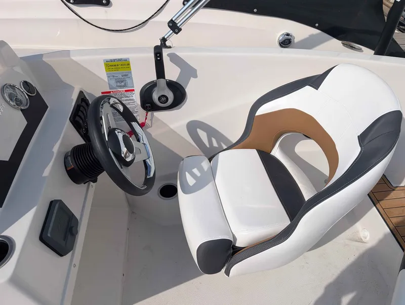 Slide: The Image of The image shows the helm of a 2025 Starcraft SVX 171 OB with a modern steering wheel and cushioned seat. - 12
