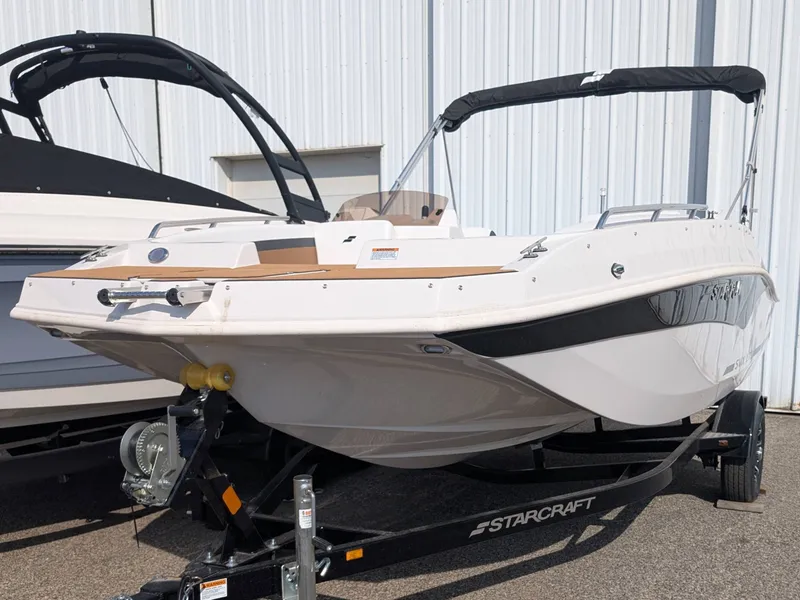 The Image of A 2025 Starcraft SVX 171 OB boat on a trailer in front of a building. - 1