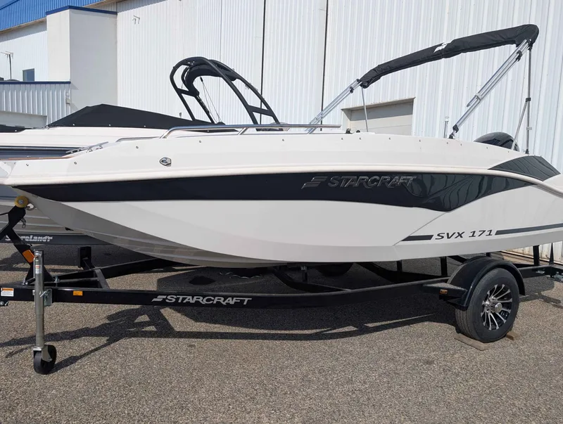 Slide: The Image of A white 2025 Starcraft SVX 171 OB boat on a trailer in front of a building. - 3