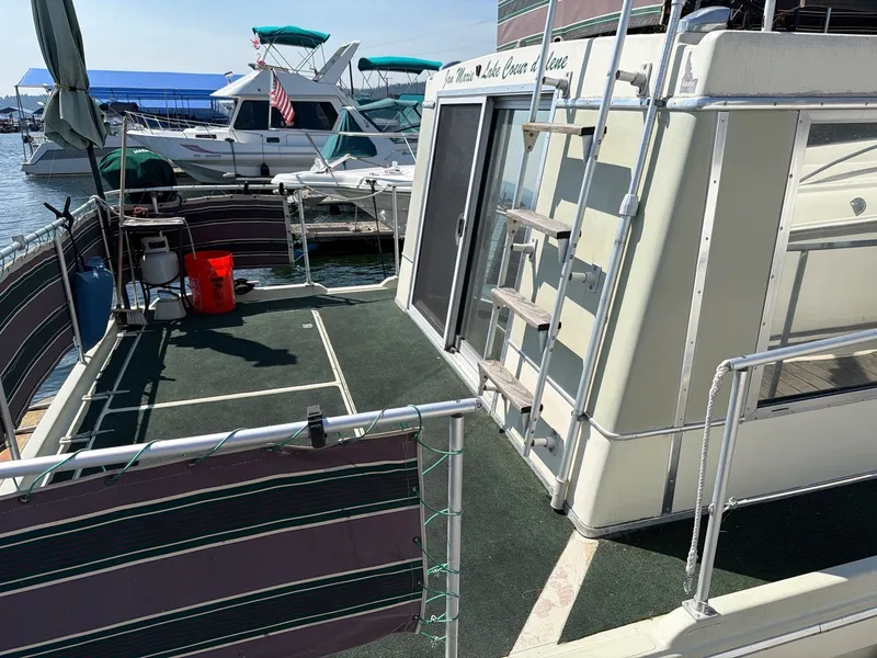 Slide: The Image of A 1977 Cruise-A-Home 40 with green carpet and railing. Boats are visible in the background. - 4