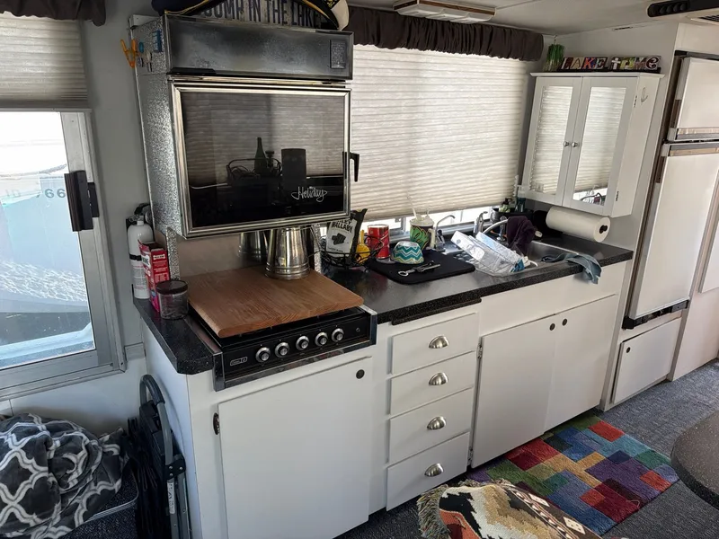 Slide: The Image of The kitchen of a 1977 Cruise-A-Home 40 with stove, cabinets, and countertop. - 14