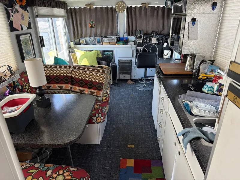 Slide: The Image of Interior of a 1977 Cruise-A-Home 40 with cozy seating area, kitchen, and helm station. - 11