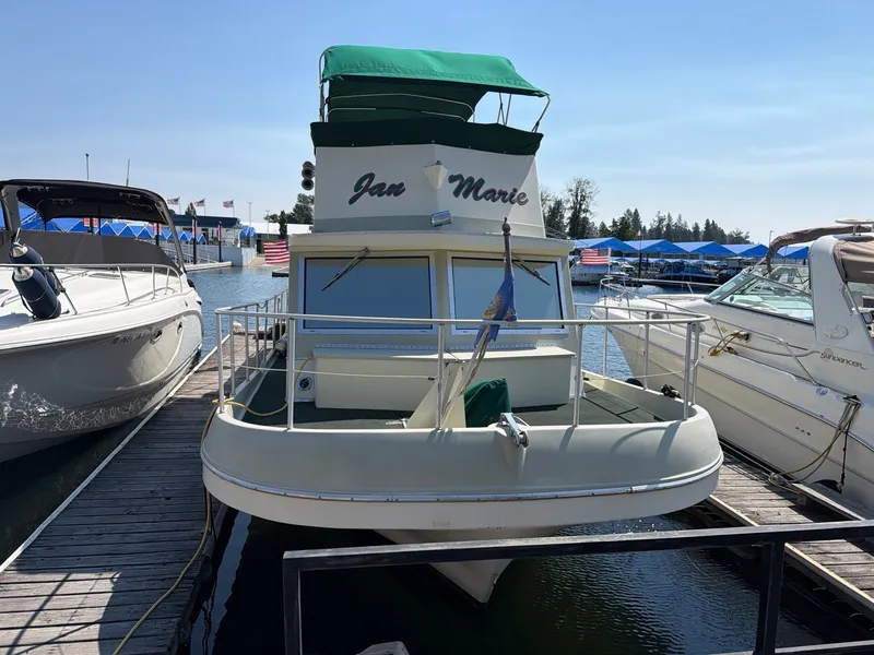 Slide: The Image of A 1977 Cruise-A-Home 40 houseboat docked. It features a green canopy. - 2