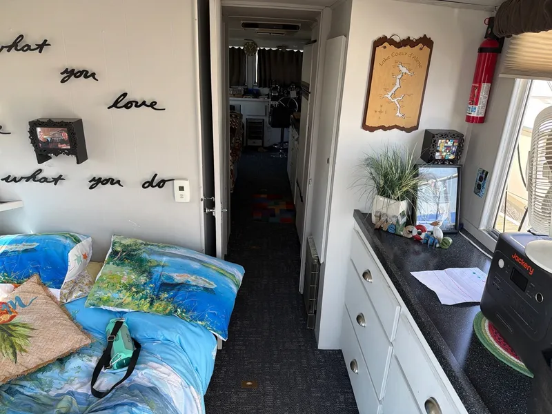 Slide: The Image of Interior of a 1977 Cruise-A-Home 40 with a cozy bed, decorations, and kitchenette. - 7