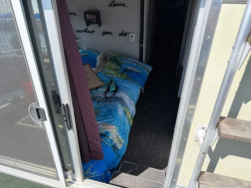 Slide: The Image of The image shows the interior of a boat with a bed featuring colorful bedding. A sliding door is visible. - 6