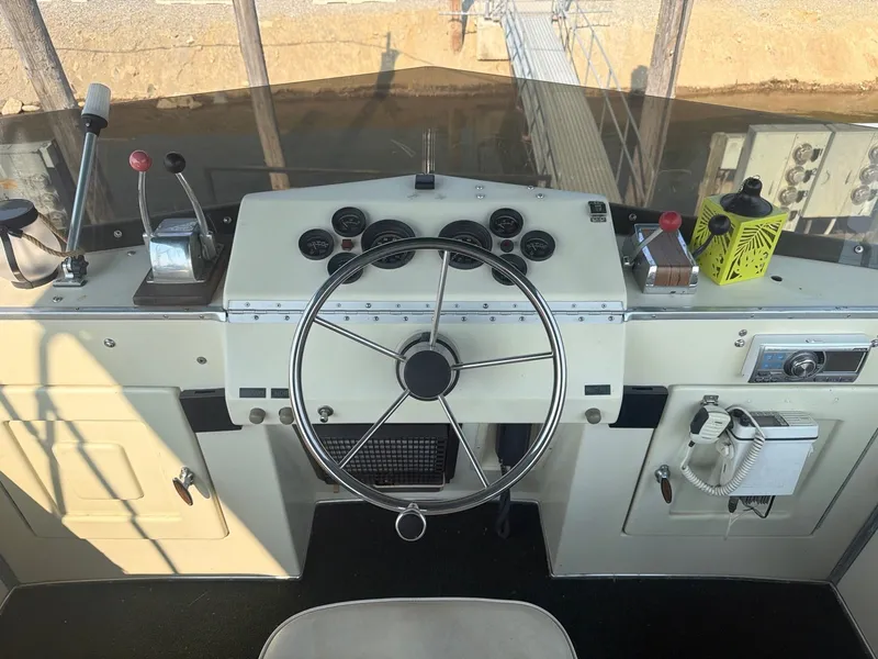 Slide: The Image of The image shows the helm of a 1977 Cruise-A-Home Corsair 40 with a large steering wheel and instruments. - 13
