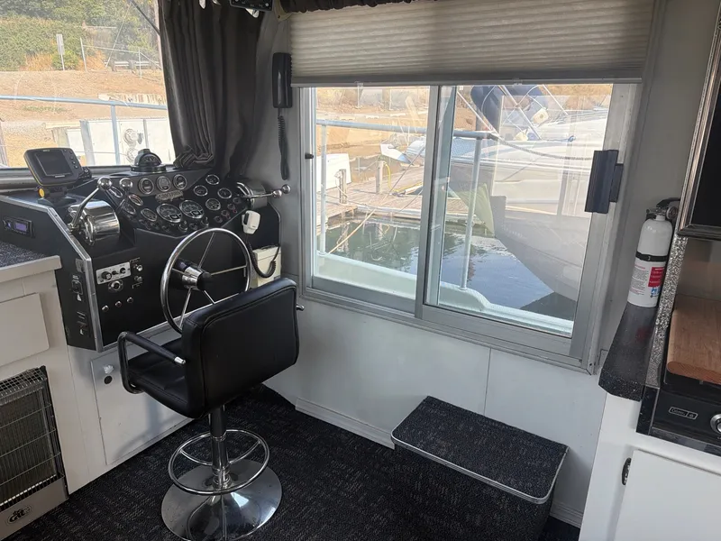 Slide: The Image of Interior of a 1977 Cruise-A-Home Corsair 40 with helm station and view of the marina. - 26