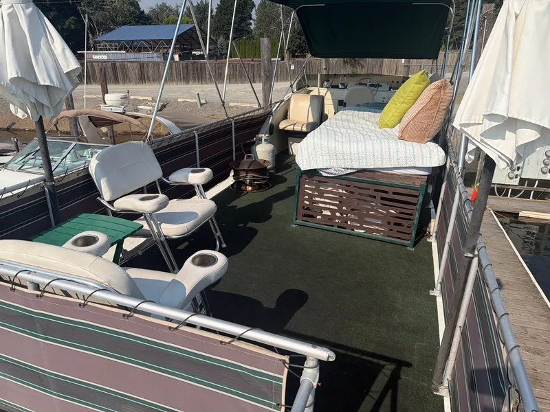 Slide: The Image of The image shows the deck of a 1977 Cruise-A-Home Corsair 40 with lounge chairs and a bed. - 9