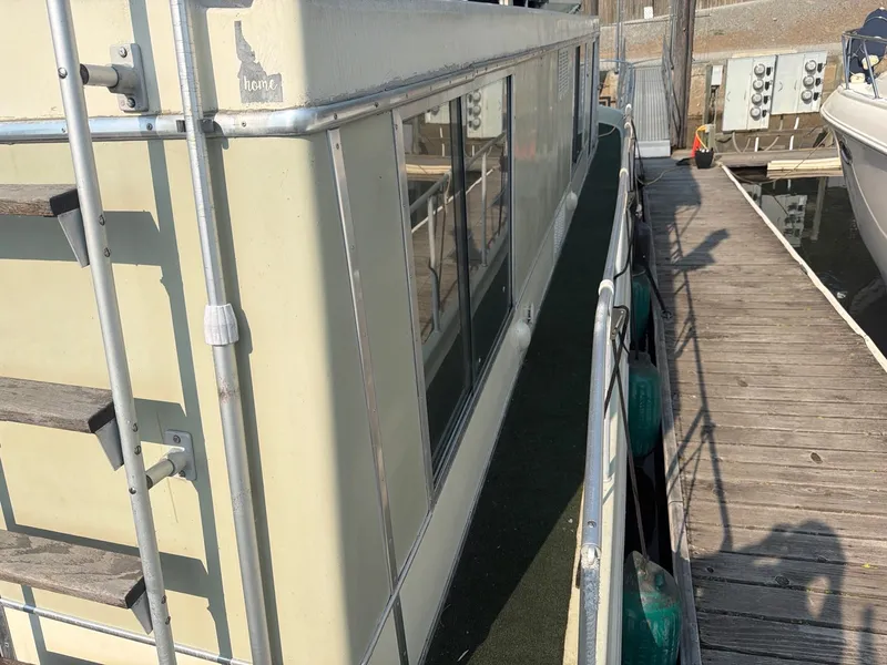 Slide: The Image of A 1977 Cruise-A-Home Corsair 40 docked. It features a spacious deck and large windows. - 7