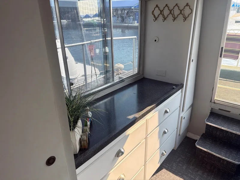 Slide: The Image of Interior view of a boat with a countertop, cabinets, and a window overlooking the water. - 18
