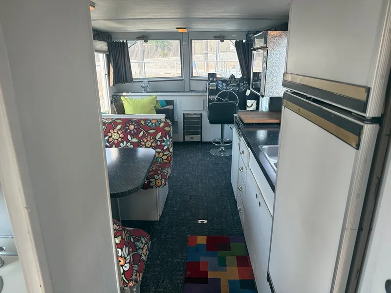 Slide: The Image of Interior of a 1977 Cruise-A-Home Corsair 40 with colorful seating area and kitchenette. - 22