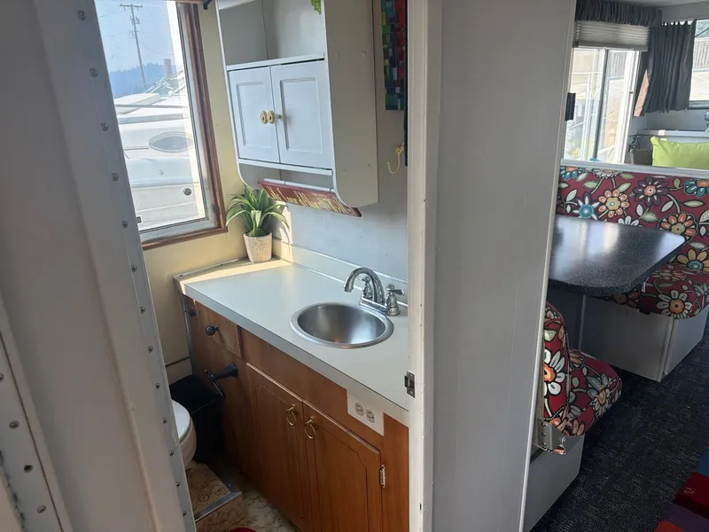 Slide: The Image of Interior of a 1977 Cruise-A-Home Corsair 40 with sink, cabinets, and cozy seating area. - 19
