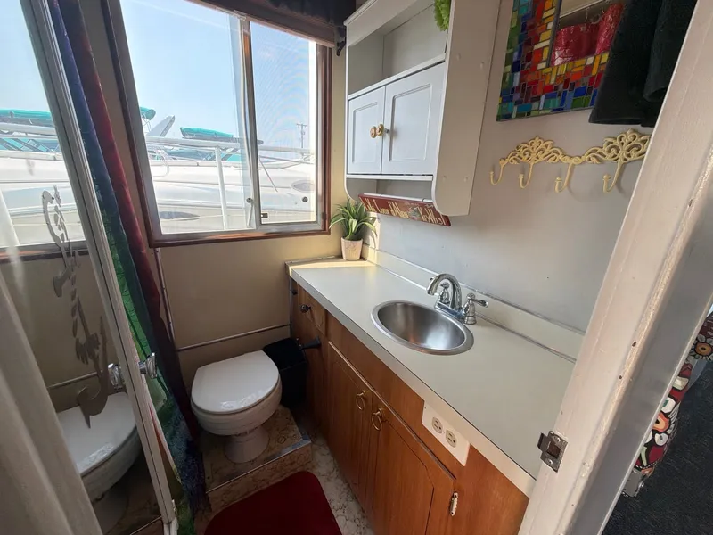 Slide: The Image of The image shows a boat bathroom with a sink, toilet, and window. - 20