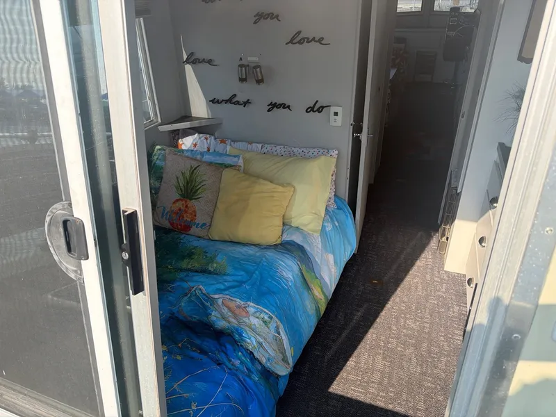 Slide: The Image of The image shows a cozy bedroom on a boat with colorful bedding and pillows. - 15