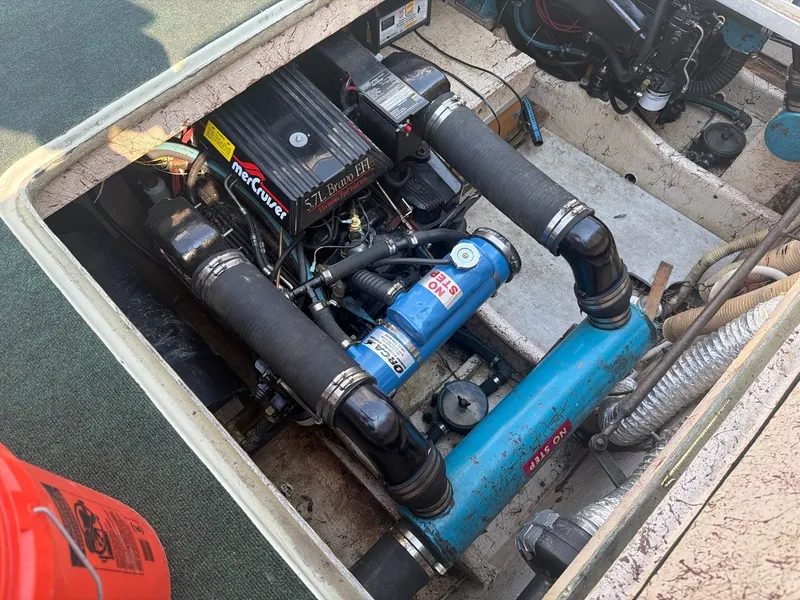 Slide: The Image of The engine compartment of a 1977 Cruise-A-Home Corsair 40 with a Mercruiser engine and blue pipes. - 30