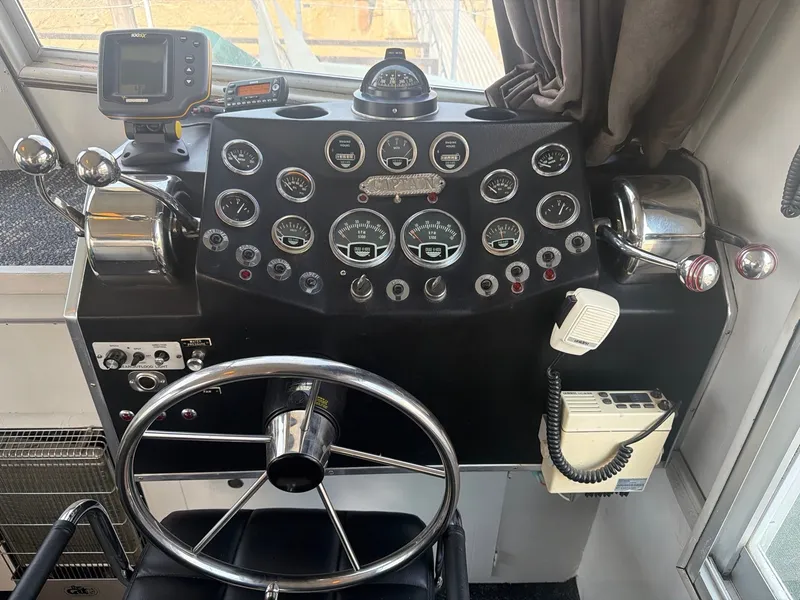 Slide: The Image of The image shows the helm of a 1977 Cruise-A-Home Corsair 40 with numerous gauges and a steering wheel. - 27