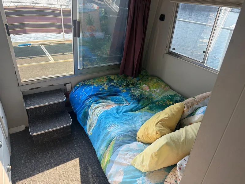 Slide: The Image of The image shows a cozy bed in a boat cabin with colorful pillows and blankets. - 17