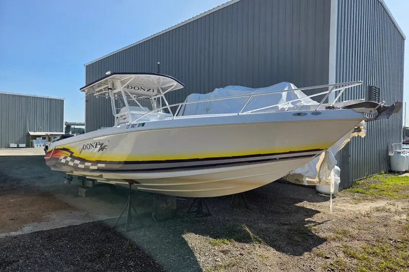 The Image of 2004 Donzi 35 ZF Cuddy boat on dry dock near metal building. - 0
