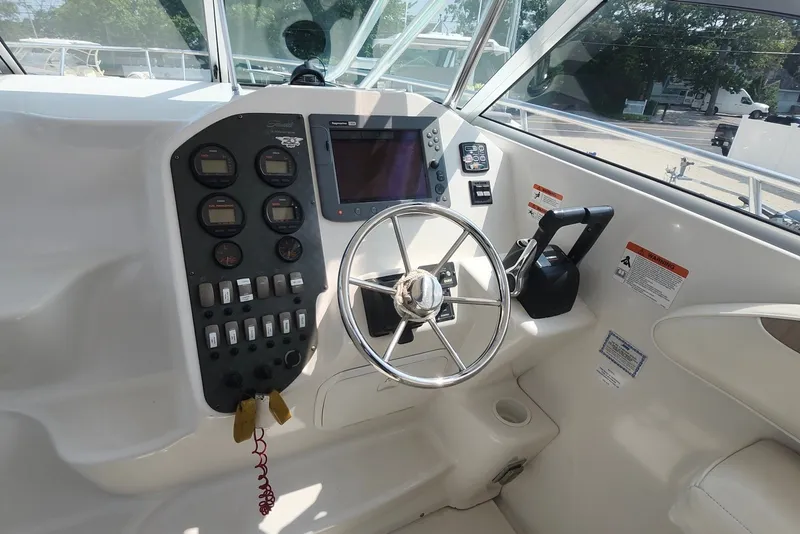 Slide: The Image of 2005 Seaswirl Striper 2901 Walkaround O/B helm with steering wheel and control panel. - 13